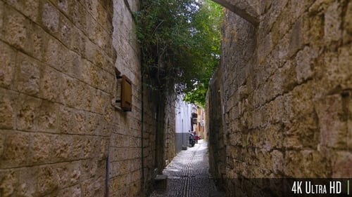 4K Narrow alley in an old town in Europe with old stones, cobblestones, and motorcycles