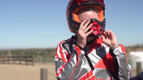 Woman Puts on Racing Helmet Outdoors