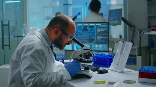 Scientist Analyzing Sample with Microscope in Laboratory