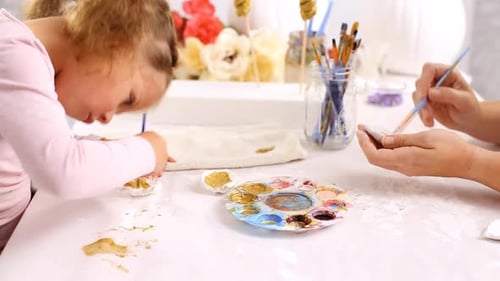 Mother and daughter painting with gold paint clay sculpted horn and ears for decorating craft pumpki