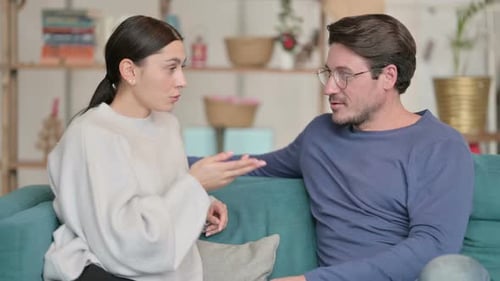 Couple Chatting Together at Home on Couch