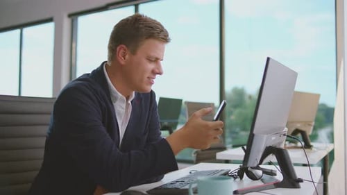 Young Adult Man Uses Phone in Modern Office