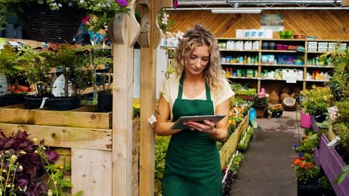 Woman Using Tablet in Plant Nursery Greenhouse