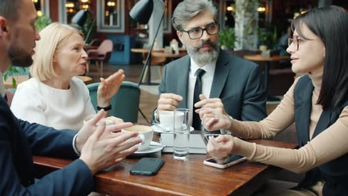Group of Entrepreneurs Men and Women Talking Discussing Business in Cafe