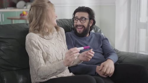 Close-up of Caucasian Blond Woman Showing Her Boyfriend or Husband Affirmative Pregnancy Test