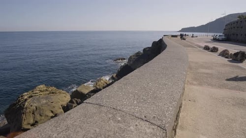 Majestic rocky coastline and concrete walkway in city of San Sebastian