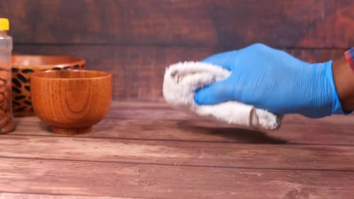 Hand with Glove Cleaning Wood Surface