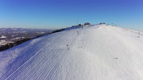 Alte Skistation an einem verschneiten Berghang mit vielen Leuten auf Skiern und Snowboards