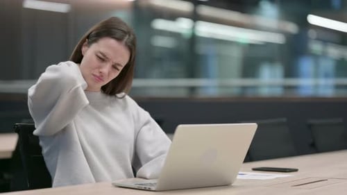 Woman Massaging Neck at Her Desk