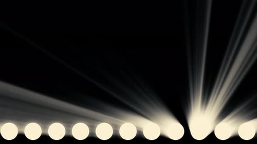 Bright shiny stage lights flashing on black background