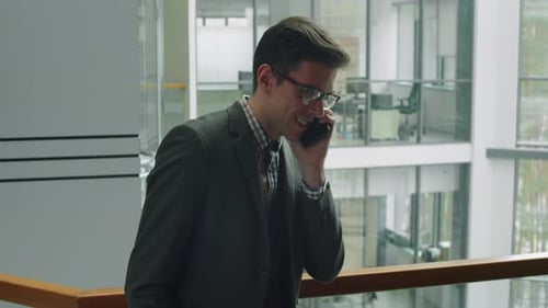 Young Businessman Speaking on Phone in Office Center