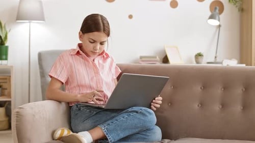 Girl Typing on Laptop Sitting on Couch
