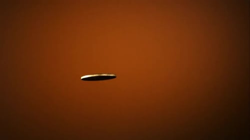 Golden coin flipping in the air in ultra slow motion