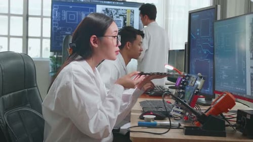 Asiatische Ingenieurin inspiziert Leiterplatten-Motherboard. Wissenschaftler entwirft industrielle Leiterplatten