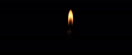 Close up single candle flame with a black background