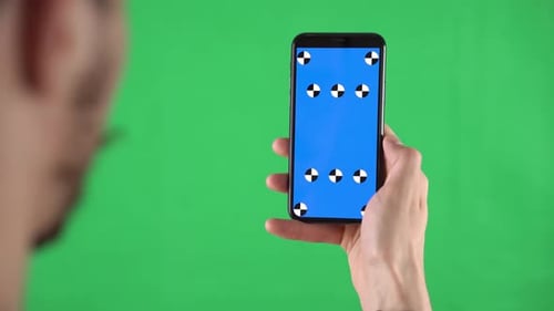 Smartphone with Tracking Points on Green Screen in Man Hands Who Swipes Left and Taps on Display