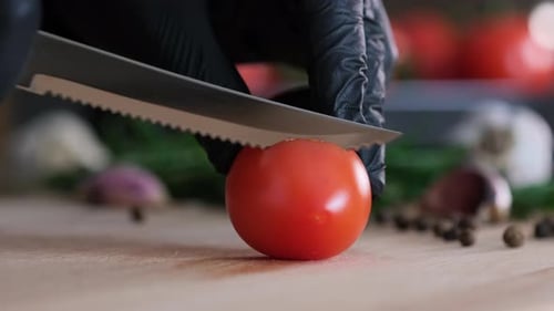 Close Up Tomato Being Sliced On Cutting Board