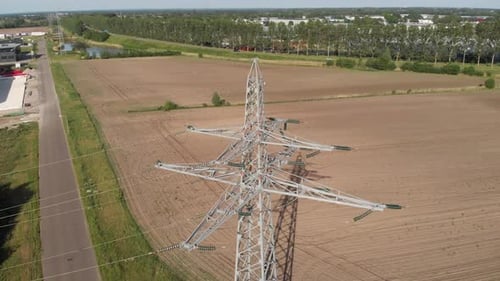 Transmission tower and power line energy supply in rural countryside setting, aerial view