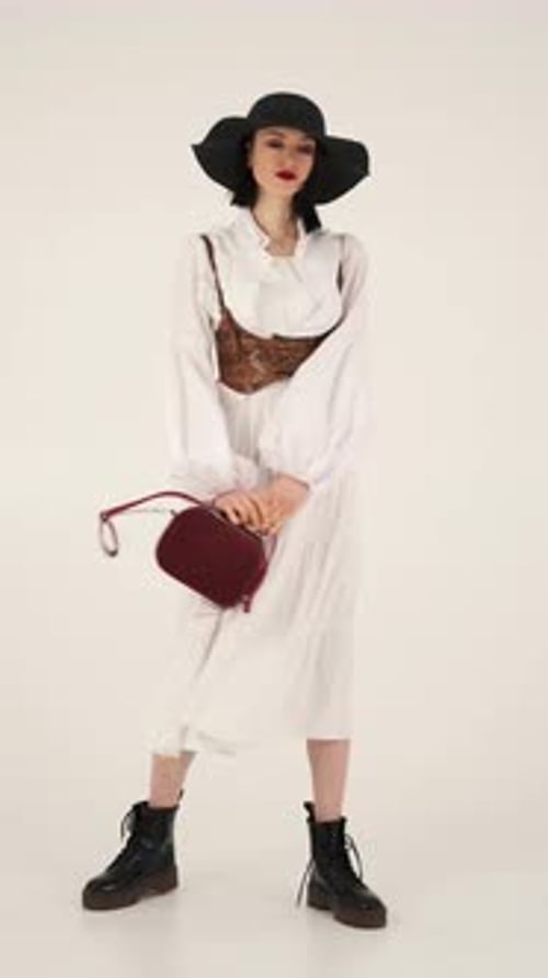 Un mannequin aux vêtements tendance change de pose en studio
