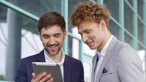 Close Up 2 Corporate Business Partners Two Businessmen Looking at Tablet and Smiling Salesmen Sign