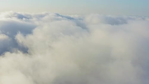 The Drone Rises From the Thick Fog Over the Beautiful Ocean of Clouds at Dawn