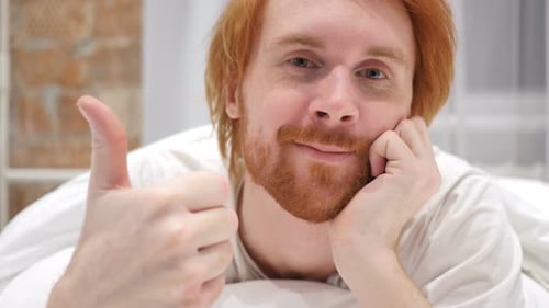 Thumbs Up par l'homme au lit