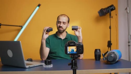 Man Vlogging About Camera Equipment At His Desk