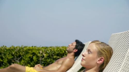Woman Smiles While Sunbathing With Man on Lawn