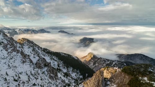 Snowy Mountain Peaks Emerging Above Clouds