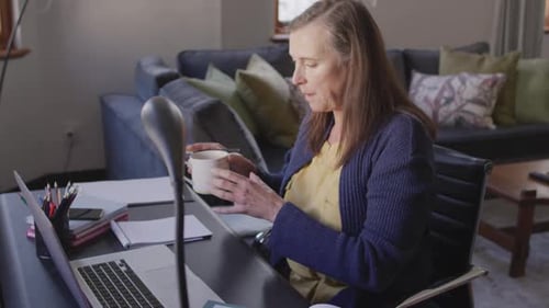 Woman Working at Home on Laptop Drinking Coffee