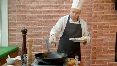 Chef cooking food in a pan, restaurant preparation