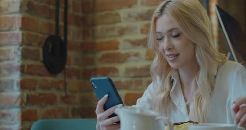 Woman Using Smartphone in Cafe Setting