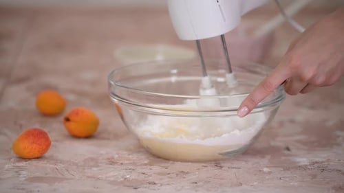 Mixing Cake Batter with Apricots in a Kitchen