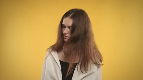 Young Woman Posing with Head Tilts on Yellow