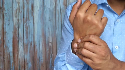 Closeup of Male Arms Holding His Painful Wrist,