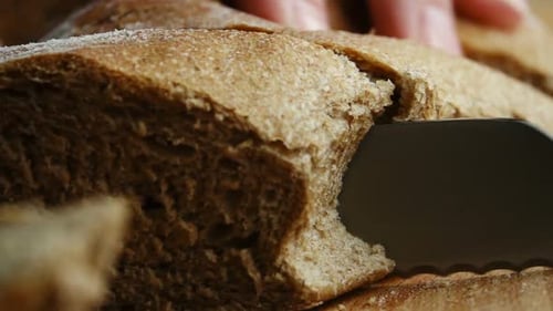 Close Up of Bread Being Sliced with Knife