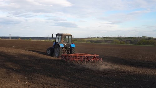 Tractor plows the farm field