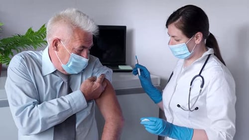 Senior Man Receives Vaccine from Doctor