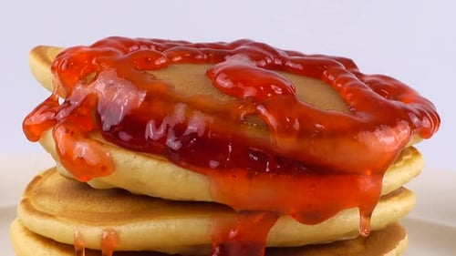 Pancakes Being Topped with Strawberry Syrup, Close Up
