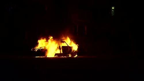 Car Completely Engulfed in Fire Near a Residential Building in the City