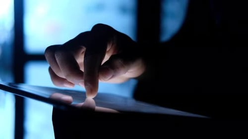 Man Hand Using Digital Tablet at Night