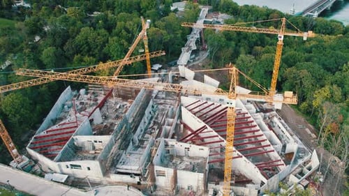 Vista aérea Construcción de un nuevo edificio con grúas torre altas en área verde