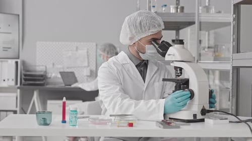Scientifique biracial utilisant un microscope