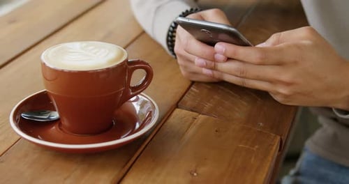 Mann benutzt Handy im Café 4k