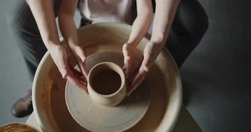 Hands Shaping Clay on Pottery Wheel in Studio