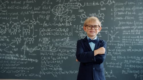 Confident Boy Stands Before Math Chalkboard