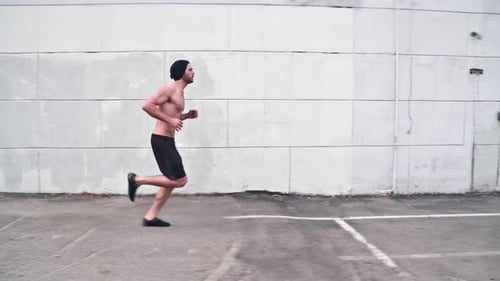 Athletic Man Running on Urban Street