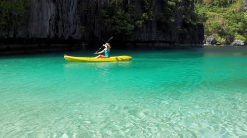 Kayaks in the Big Lagoon with Turquoise Clean Water, Tropical Forest, Rocks in El Nido Island