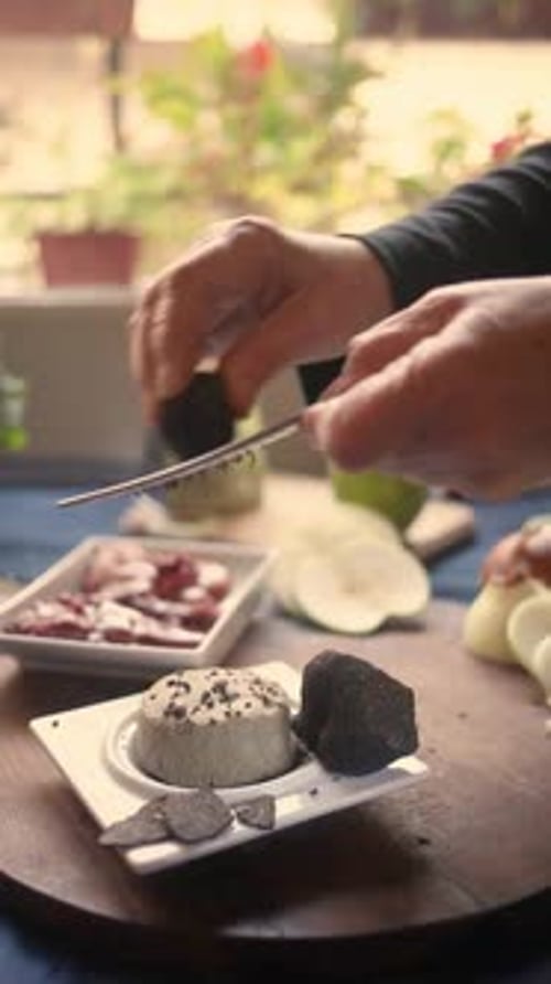 Hands Grate Truffle Over Dessert at Table
