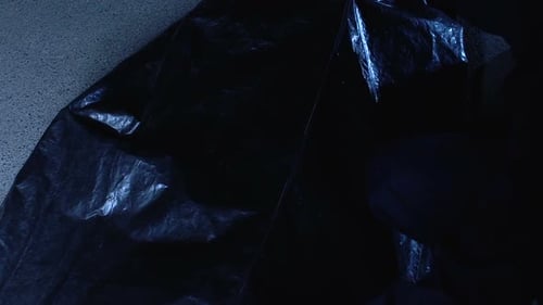 Man Unzips Black Bag and Reveals Woman